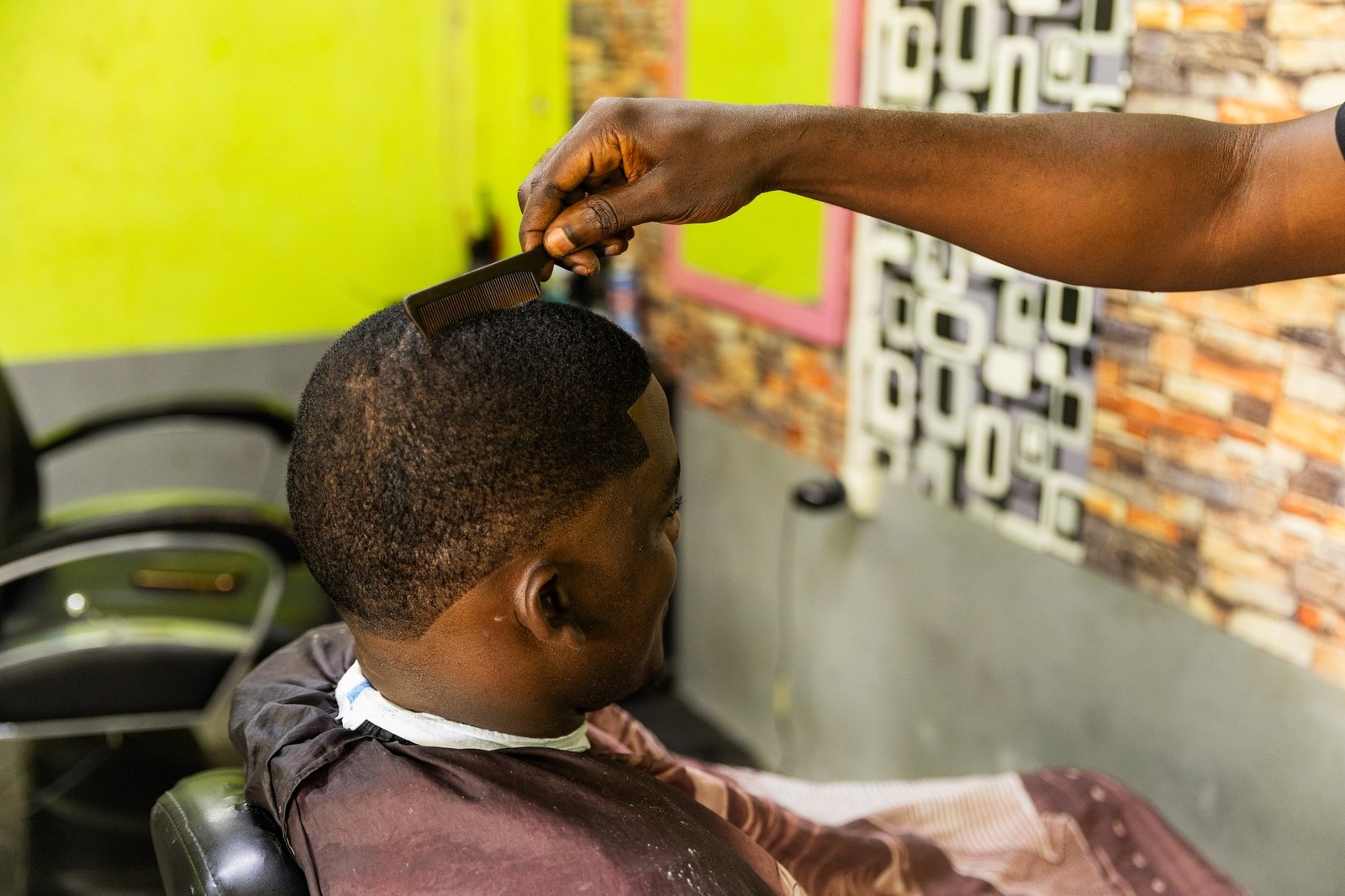 A man is getting his hair cut by a barber, close of the comb