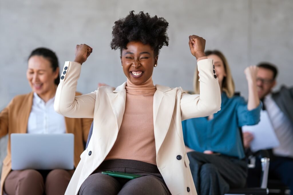 Happy young African American business woman in startup office. Business success black woman.